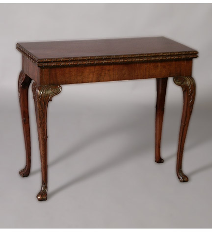 George II mahogany concertina-action games table with egg & dart carved molded edge & raised on cabriole legs.