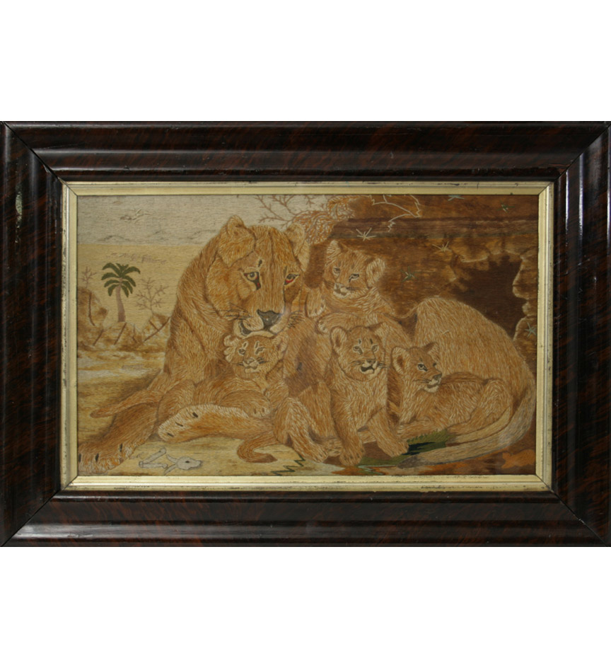 A needlework pucture of a lioness and her cubs in faux rosewood frame.