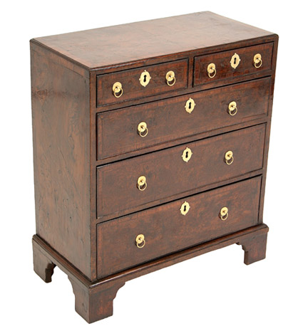 A fine George l yewwood bachelor's chest of excellent color, the quarter-paneled top with kingwood cross-banding and tulipwood inlay, on bracket feet. (Feet and handles of later date.)