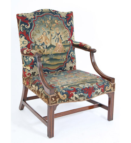 George III needlepoint upholstered mahogany Gainsborough chair, the arched back above a serpentine seat, padded armrests and molded square legs; the needlepoint depicting animal and and figural reserves.