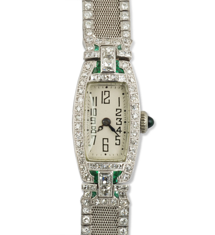 An Art Deco diamond and calibre emerald diamond watch of tonneau shape, with a diamond bordered mesh band, in platinum.  Paul Ditisheim movement. Atw. 3.50 cts.