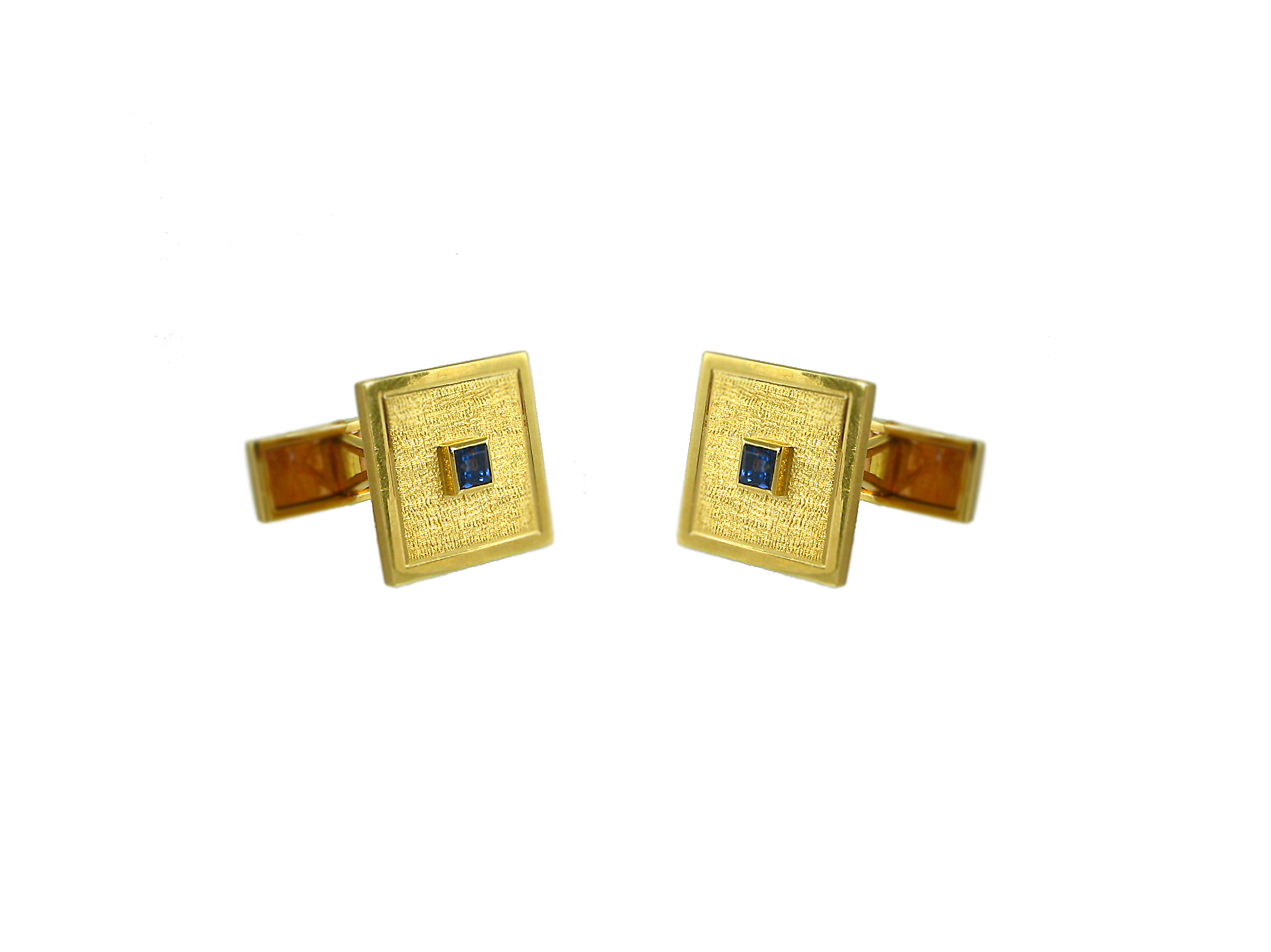 A pair of gold cufflinks of square textured design, set with square sapphires, in 18k. Van Cleef & Arpels, France.