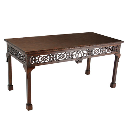 A George III mahogany serving table with a deep open fretwork apron, the rectangular top with a carved edge, raised on lappet carved legs ending in block feet.