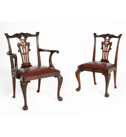 Set of 12 carved mahogany Chippendale-style dining chairs, the pierced back splat with leafy scrolls and tassel motif, with drop-in seat and raised on cabriole legs ending in paw feet.
Seat height: 18 1/2