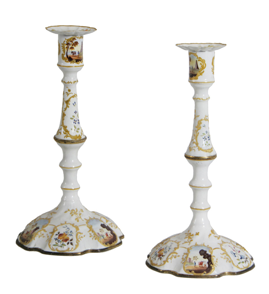 A pair of South Staffordshire enamel candlesticks, the base decorated with reserves of country scenes.