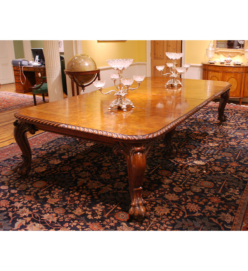 A nineteenth century large burr oak dining table with five leaves.  The highly figured top with gadrooned edge and raised on lion paw cabriole legs.