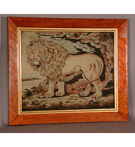 A fine woolwork of a well-modeled standing lion, in a birdseye maple frame.