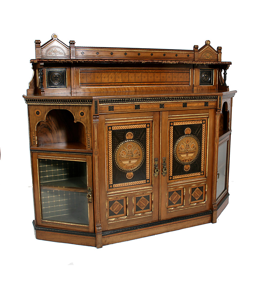 Arts and Crafts 19th c. exhibition quality walnut and inlaid side cabinet, by Lamb of Manchester and probably designed by Bruce Talbert.  This elaborate cabinet centers a pair of marquetry doors depicting a bowl of flowers, the angled sides with trefoil recesses above glazed door side cabinets, all on a plinth base.