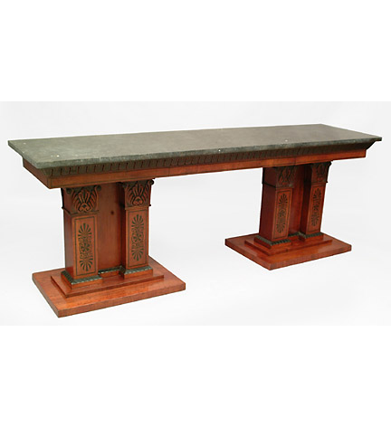 Regency marble-topped mahogany serving table in the manner of Bullock, the frieze with carved and ebonized leaf-tip motifs and three blind drawers, raised on a pair of broad double-column supports with carved anthemion capitals and ebonized decoration.