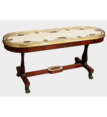 George III ormolu-mounted scagliola and plaster surtout de table now mounted on a mahogany trestle-end table base.  The top in three sections and decorated in the late 18th c. Etruscan style with four medallions and with seated maidens emblematic of the four seasons, the central panel with two tablets one depicting Ceres, the other depicting Neptune or a river god, each tablet and medallion with vine-draped Bacchic panther, enclosed by a border of laurel with pearled edge, divided by six tablets depicting vases, with pierced ormolu gallery.  The table with a plain frieze and lyre end-supports with panelled plinths joined by a panelled stretcher centered by a painted plater oval depicting a reclining maiden, on bronzed paw feet with sunk brass casters.