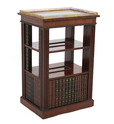 A Regency mahogany bookstand with brass gallery over two open shelves and faux bookbindings to the sides and base.