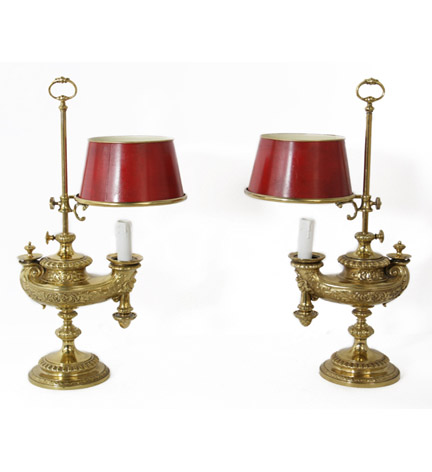 A pair of 19 c. brass chased and decorated oil lamps with red tole shades.
