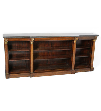 A Regency marble-topped rosewood breakfront open bookcase with bronze neoclassical mask mounts and plinth base.