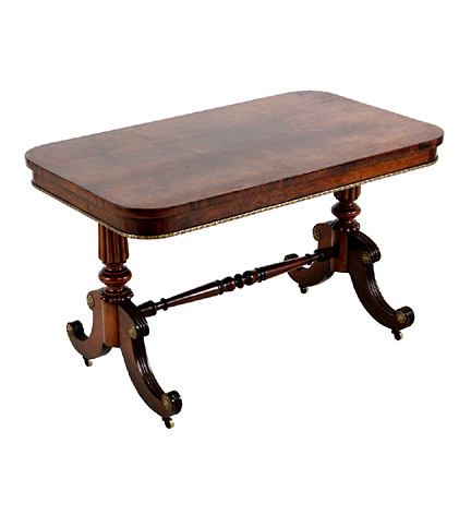 A Regency rosewood low library table, with reeded tapering trestle supports joined by a stretcher and ending in splayed feet.  Alterations.