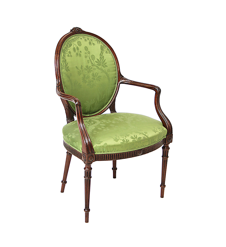 A George III mahogany oval-backed upholstered open armchair in the Hepplewhite taste.