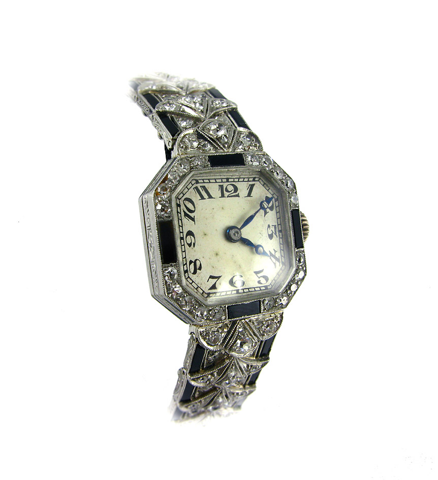 An Art Deco diamond watch of scalloped design set with onyx baguette accents, in platinum.