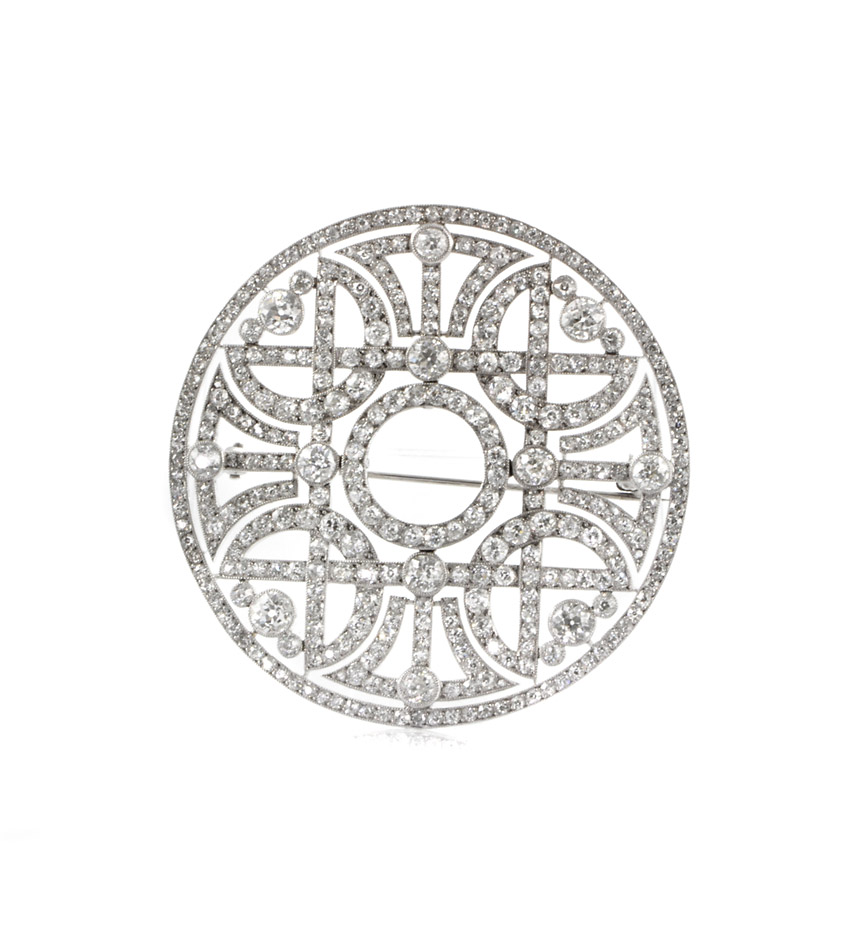 An Art Deco diamond brooch of open circular design with a woven quatrefoil design, in platinum. Atw Dia. 11.34 cts. H-K. SI1/VS2.
